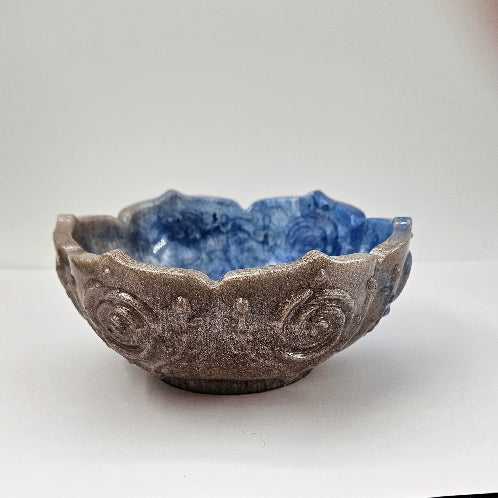 Decorative blue and silver flower-shaped resin bowl showing off the silver half.