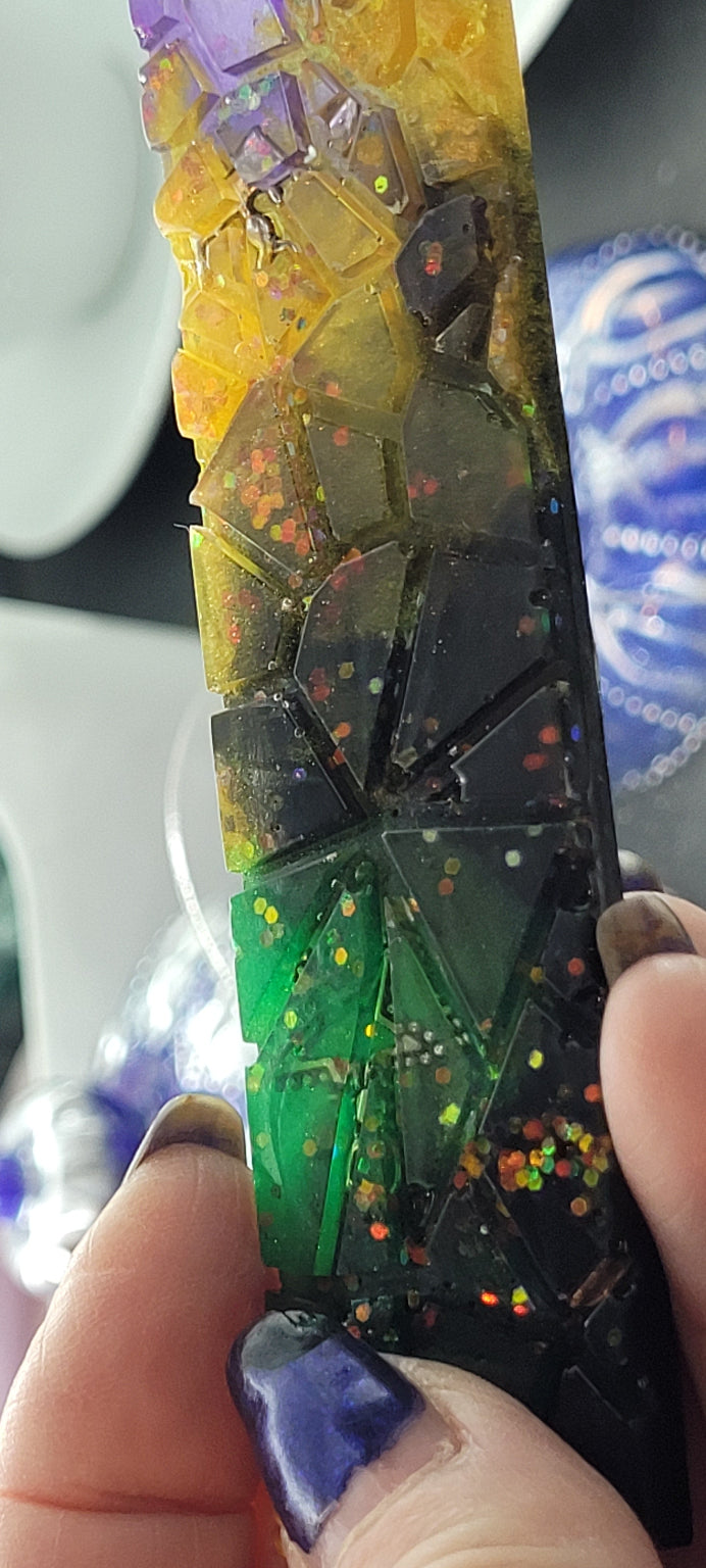 Colorful resin bookmark with embedded stars held by a hand.