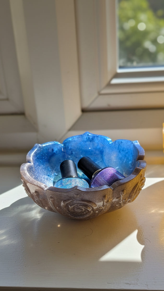 Decorative blue and silver flower-shaped  resin bowl with sunlight streaming through a window.