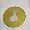 Gold coloured resin circular drinks coaster. Inside is a faux leather pair of ballroom dancers.